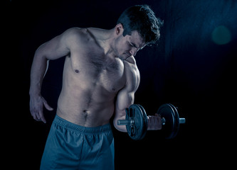 Fototapeta na wymiar young muscular man lifting weights over dark background