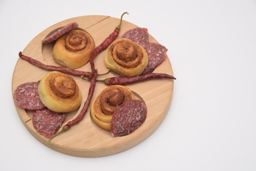 Salted dough. sliced sausage and chili peppers on a wooden board