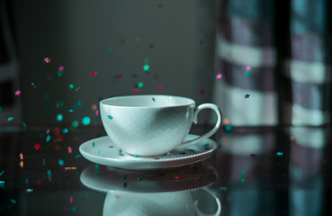 A coffee cup with confetti flying around it.