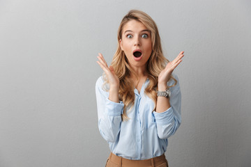 Photo of shocked blond businesswoman with long curly hair screaming and throwing up hands