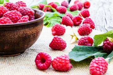 Ripe red raspberry lies on the background of old boards. Selective focus.