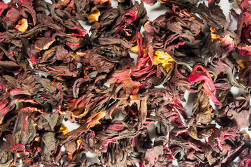 Dried flowers petals background. Red, yellow and brown colors backdrop for design projects. Sudan rose karkade tea