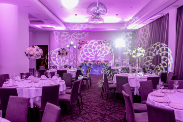 Wedding banquet in blue and white tones. Beautiful table setting with crockery and white flower arrangements in a vase on a high stem for a party, wedding reception or other festive event