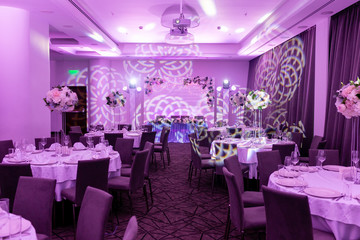 Wedding banquet in blue and white tones. Beautiful table setting with crockery and white flower arrangements in a vase on a high stem for a party, wedding reception or other festive event