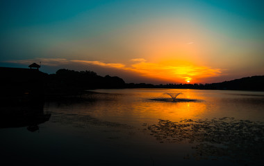 Beautiful blazing sunset landscape at black sea and orange sky above it with awesome sun golden reflection on calm waves as a background. Amazing summer sunset view on the beach. Russian nature, Sochi