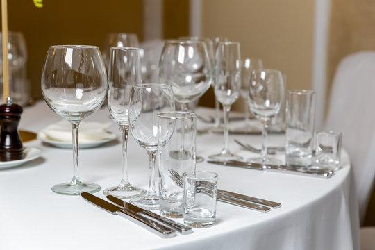 Beautiful table setting with crockery for a party, wedding reception or other festive event. Empty glassware and cutlery for catered event dinner. Horizontal photo