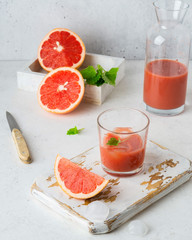 Ripe cut grapefruits and glass of freshly squeezed grapefruit juice