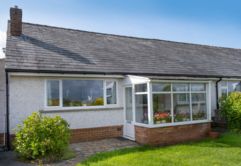 UK 60's bungalow with slate roof, white quartz render and upvc double glazed windows and front...