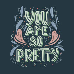 You are so pretty hand drawn lettering with doodle heart and leaves decoration on dark background. Cute compliment for card, print on t-shirt and cup. Inspirational quote for love expression