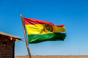 Bolivian Flag waving in the wind against blue sky background