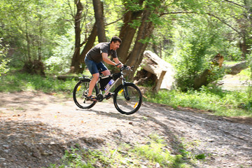 Fototapeta na wymiar The cyclist takes acceleration to overcome the ford