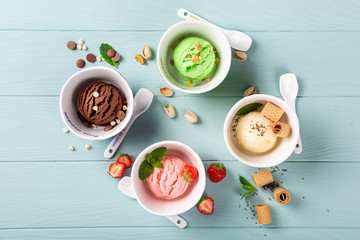 Flat lay of homemade assorted ice cream on light blue wooden background. Healthy summer food concept. Top view, copy space.