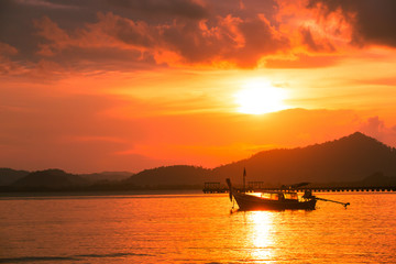 Silhouette of beautiful sunset with fishing boat