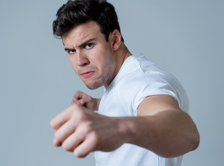 Young attractive man angry and furious in boxing stance ready to fight