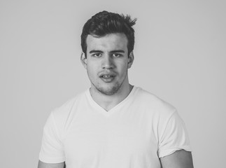 Natural portrait of young attractive man in his 20s looking and posing with neutral face expression