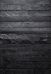 Black wood texture vertical wall background top view.