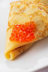 Pancakes with a red caviar stuffing. White background. Close up. Selective focus.