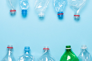 Plastic bottles on blue background top view. Recycle plastic waste pollution concept template.