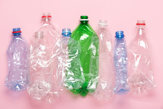 Plastic bottles on pink pastel background top view. Eco plastic recycling concept.