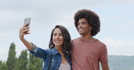 Romantic couple taking a selfie with smartphone in rural town of Assisi.Portrait medium shot.Friends italian trip in Umbria.4k slow motion