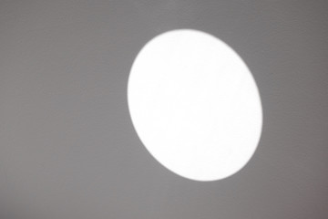The reflection of the sun on a gray wall. Mirror reflection