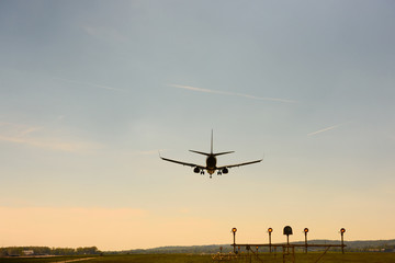 Fototapeta na wymiar Airplane airport landing at sunset