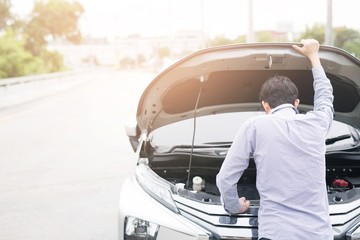 Men are stressed because the car is broken by the way, waiting for help