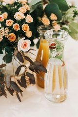 Romantic table setting detail with pink rose flowers and drinks.
