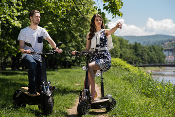 couple on electric scooters enjoying in nature 