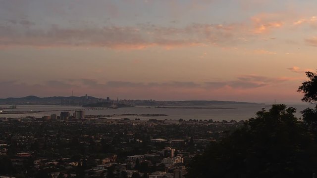 Sun setting over San Francisco and the Golden Gate Bridge on a clear Summer night. Seen from Berkeley Hills, California.