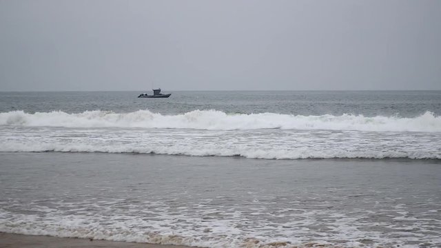 A fishing boat anchored just off the shore of Zuma beach in California.