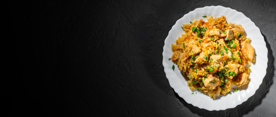 Chicken Breast with Rice and vegetables in white plate on dark black background