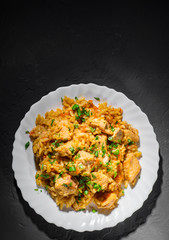 Chicken Breast with Rice and vegetables in white plate on dark black background