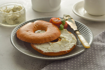 Breakfast with bagels and cheese, cherry, basil, tea cup. Healthy food.