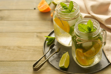 Homemade lemonade with lime, mint in a mason jar on a wooden rustic table. Summer drinks. Copy space.