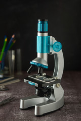 Education, science and children concept. Microscope isolated on black background. Studying biology at school laboratory.