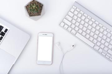 Modern white office work table with smartphone mock up laptop ,earphone and catus, top view