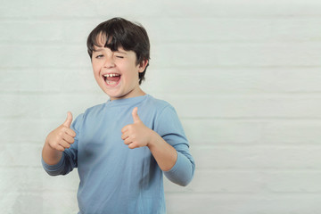 Little boy smiling showing thumbs up