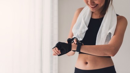 Asian women resting and using smart watch after play yoga and exercise at home background with copy space.Concept of sport technology to checking health data.