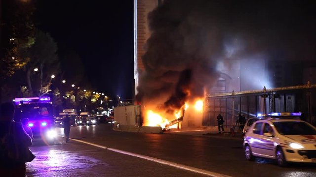 Paris, France - April 6, 2019: Fire in Paris with cars and firemens near Museum. Firefighter, Dark Smoke, burning fire, monument. Fireman running and policeman in police car passing by with speed.