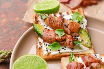 Tasty toasts with bacon on plate, closeup