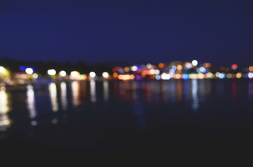 Abstract colorful bokeh effect city lights reflected over night water outdoor background. - Image
