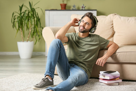 Young Man Listening To Audiobook At Home