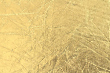 Texture of pressed fabric with metallized gold plating. Golden crumpled background.Shiny surface....