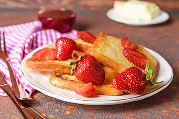 Plate with tasty French toasts and strawberry on table
