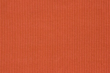 Ribbed textile material, in fine-knit stretch fabric. Knitwear texture. Burnt orange color background.