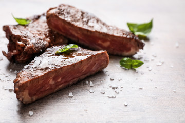 Tasty grilled meat on grey background