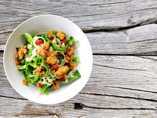 Fresh salad tomatoes and mixed greens (arugula, mesclun, mache) on wooden background close up. Healthy food.