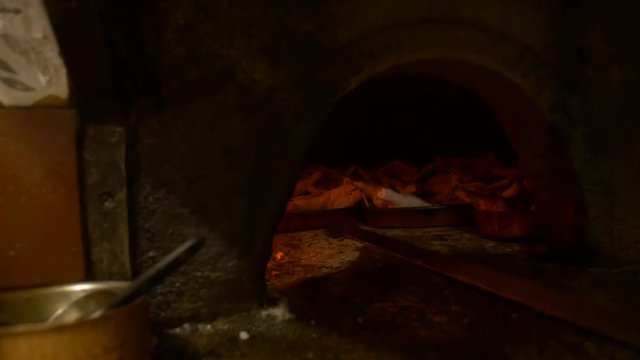 Spanish suckling pig being cooked in a wood fire oven.