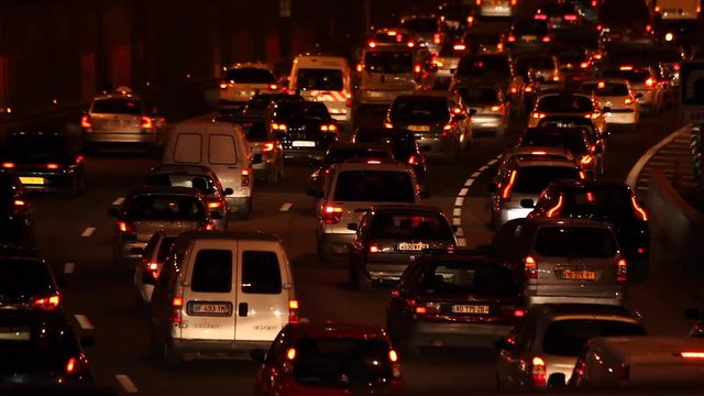Paris, France - April 6, 2019: Car Traffic by night at Paris Parc Des Princes soccer stadium taken from bridge view. Lights, cars, fires, trees, bus, blur effect. Lot of vehicles. Close up.